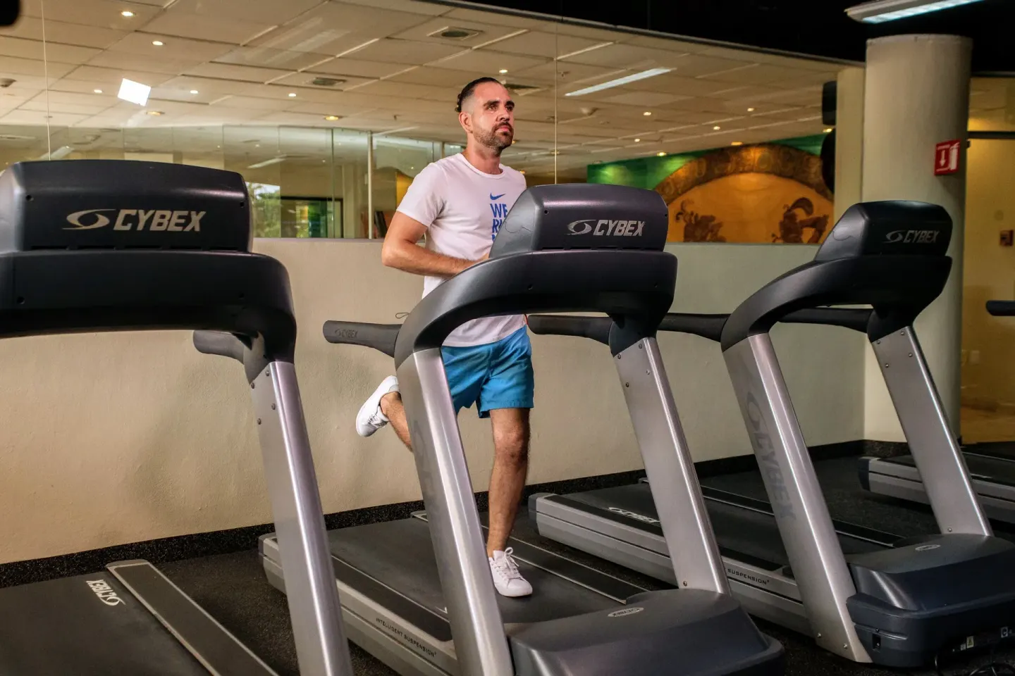 Guest using a treadmill in the fitness center at Wyndham Grand Cancun Resort & Villas.