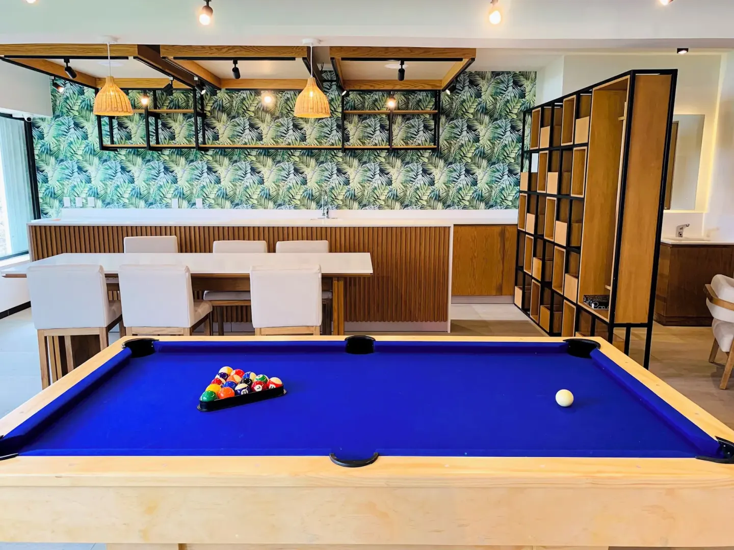 Pool table beside tables and tropical wall decor at Wyndham Grand Cancun Resort & Villas.