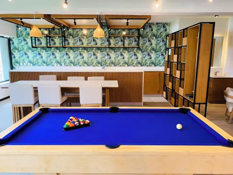 Pool table beside tables and tropical wall decor at Wyndham Grand Cancun Resort & Villas.
