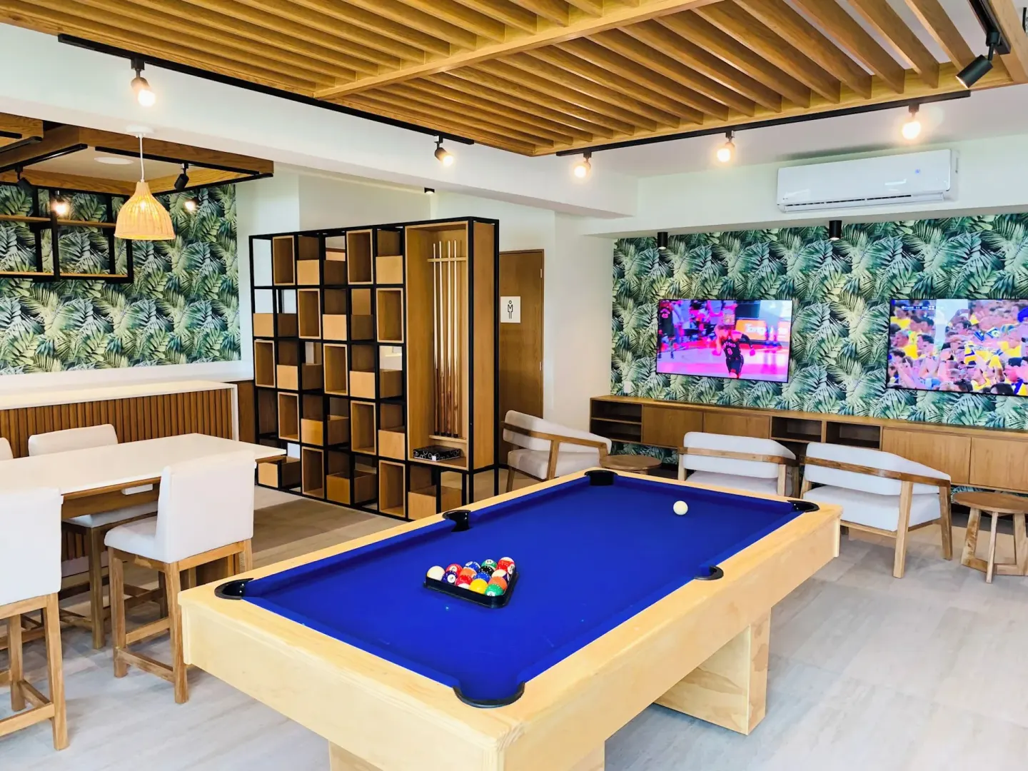 Game room with blue pool table and lounge seating at Wyndham Grand Cancun Resort & Villas.