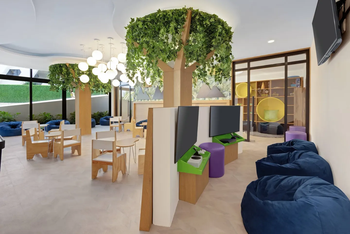 Kids club play lounge with beanbags and game screens at Wyndham Grand Cancun Resort & Villas.