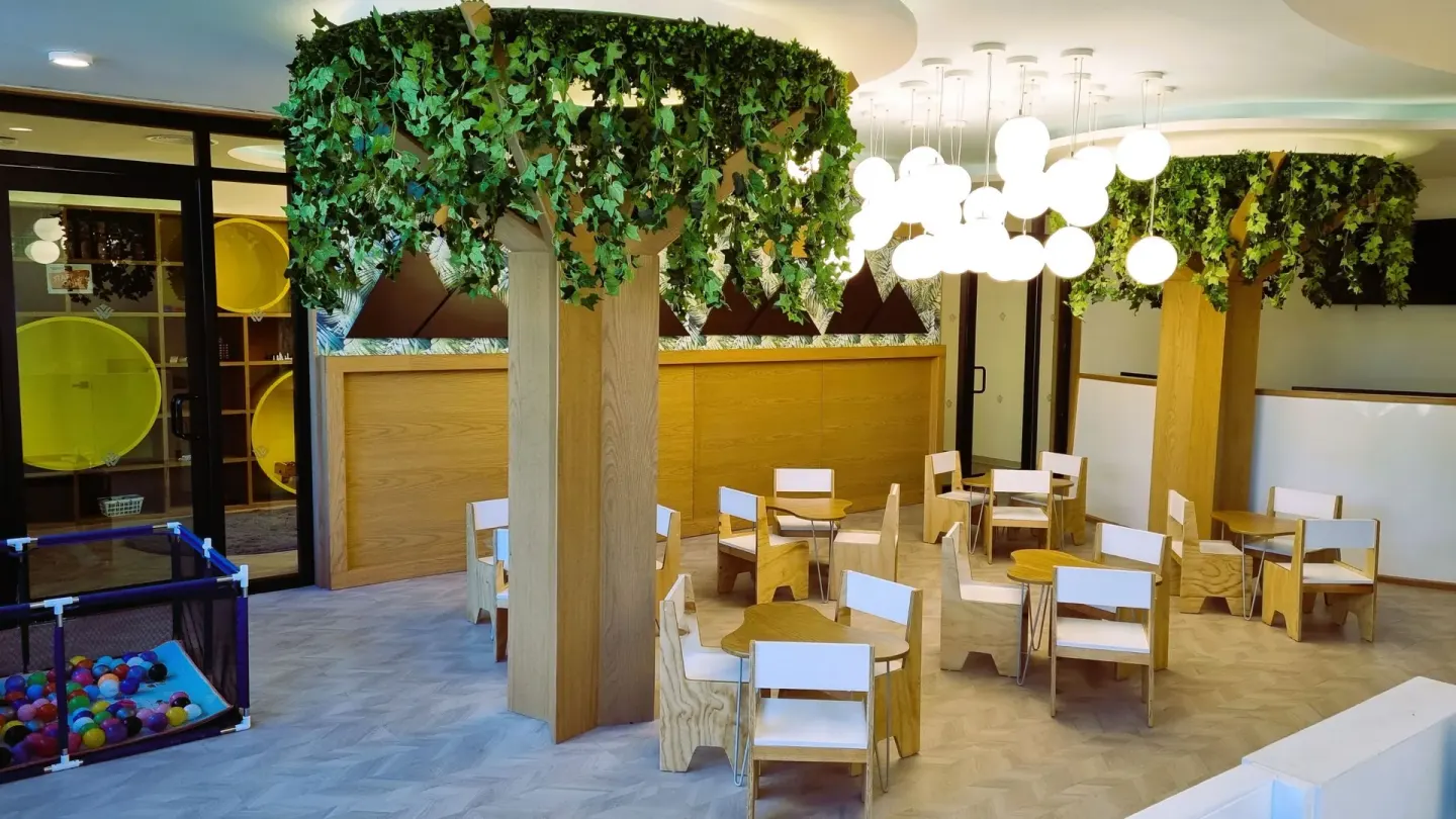 Kids club seating area at Wyndham Grand Cancun Resort & Villas with small tables and play equipment.