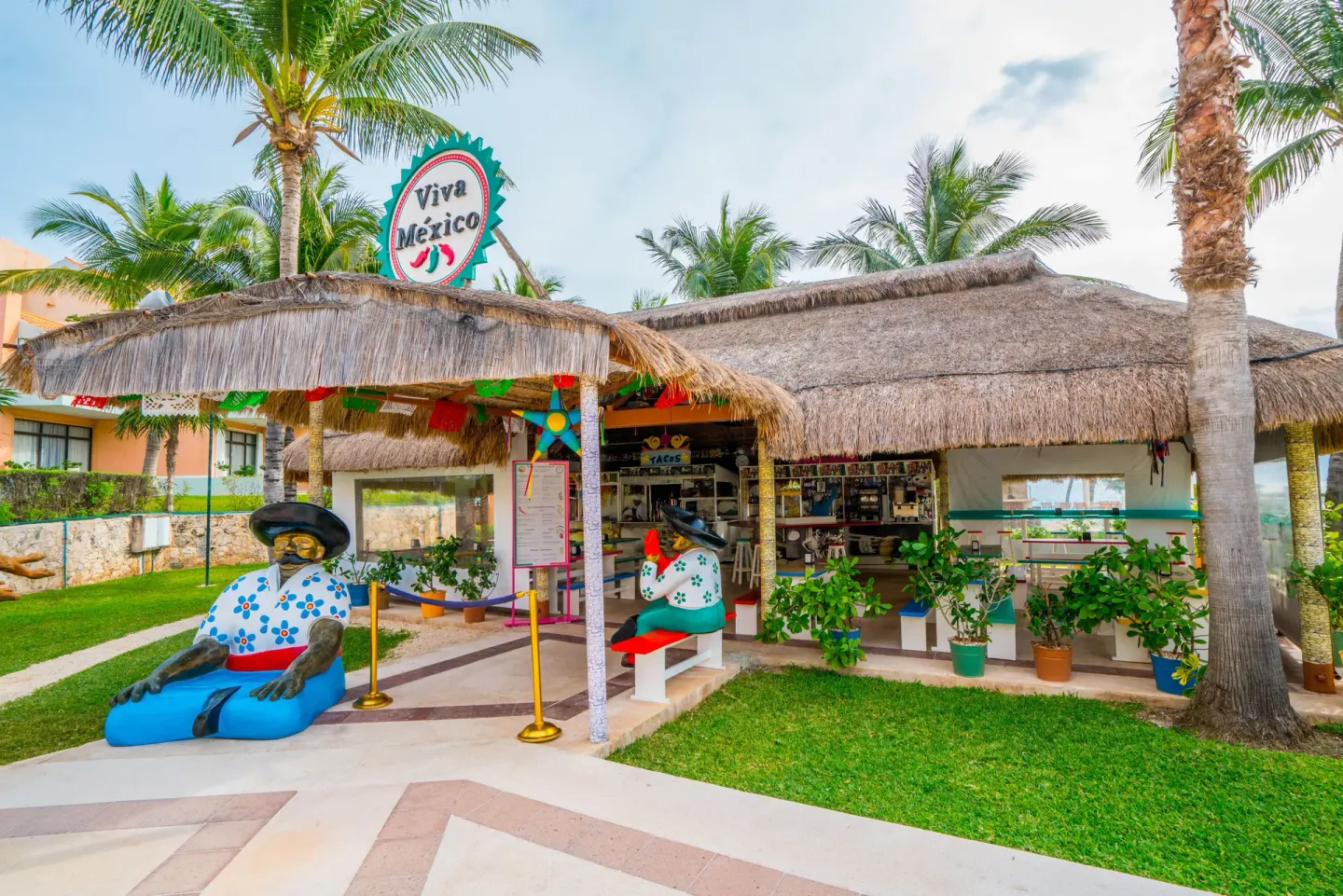 Thatched Mexican-themed hut and lawn at Wyndham Grand Cancun Resort & Villas.