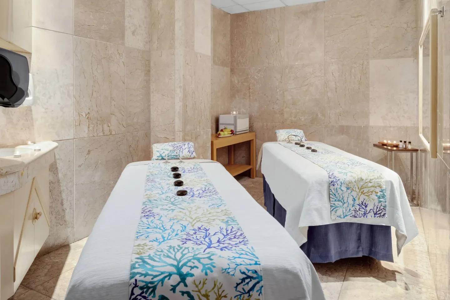 Spa treatment room at Wyndham Grand Cancun Resort & Villas with two massage tables and hot stones.