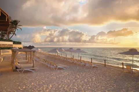 Sunrise beach loungers and umbrellas at Wyndham Grand Cancun Resort & Villas.