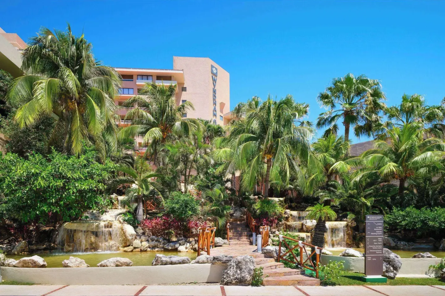 Tropical garden waterfalls and palm trees at Wyndham Grand Cancun Resort & Villas.