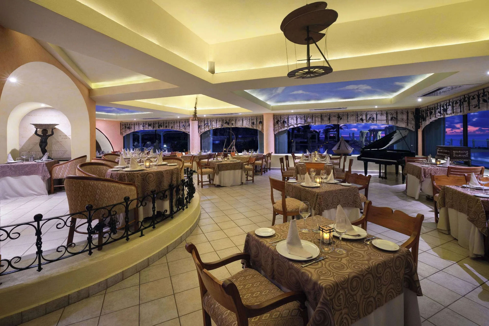 Elegant restaurant dining room at Wyndham Grand Cancun Resort & Villas with set tables and a grand piano.