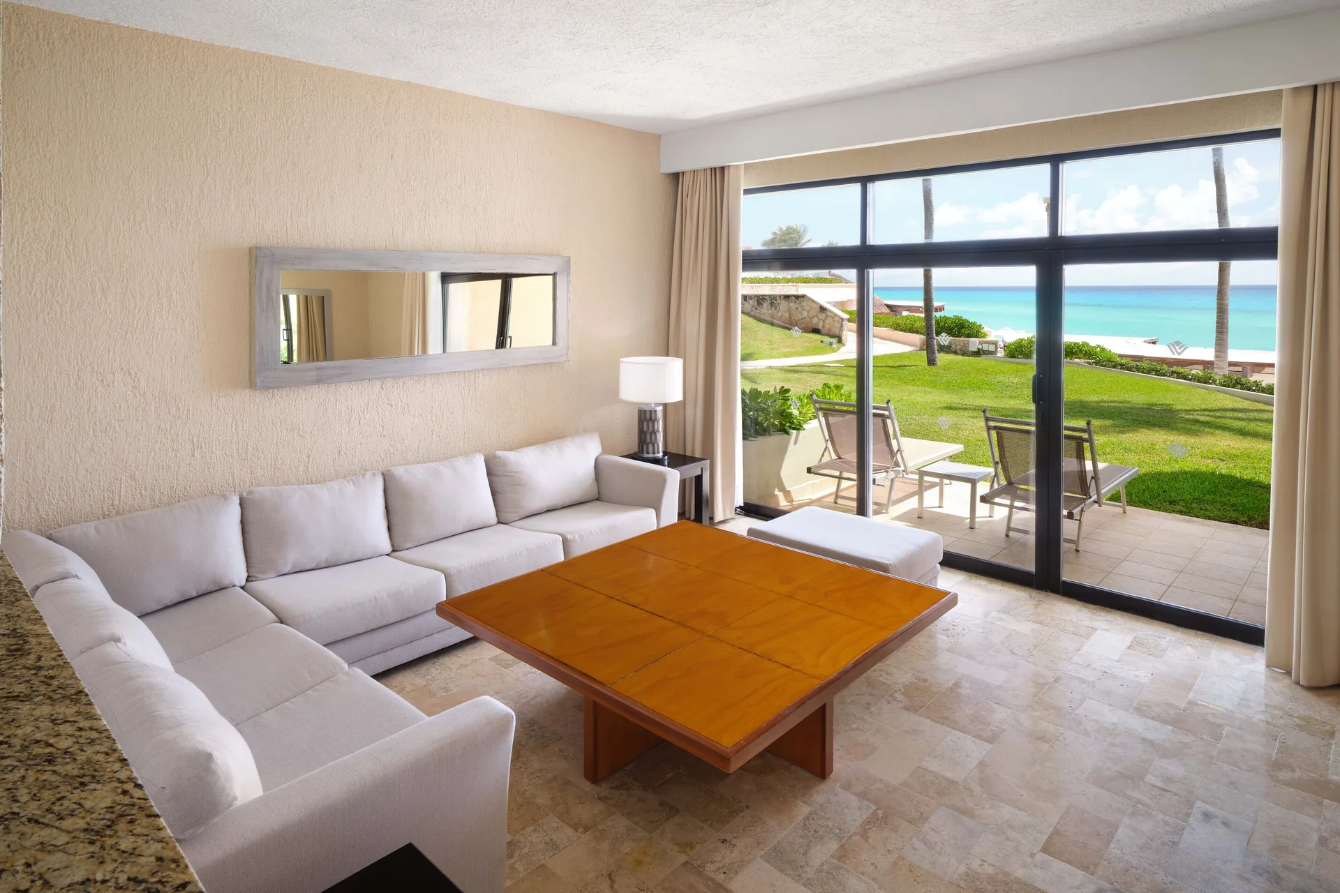 Non-smoking living room with patio and ocean view at Wyndham Grand Cancun Resort & Villas.