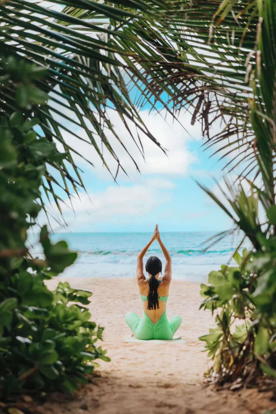 Beach yoga framed by palms at Wyndham Palmas Beach and Golf Boutique Resort.