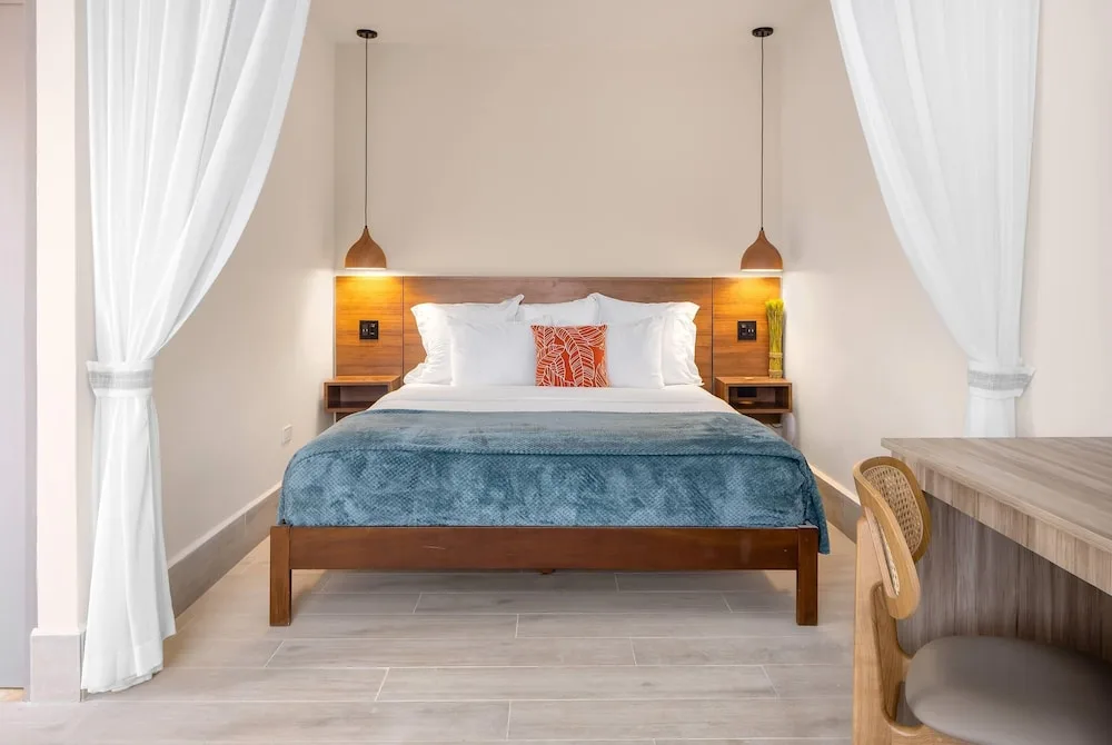 King bed and writing desk in a guest room at Wyndham Palmas Beach and Golf Boutique Resort.