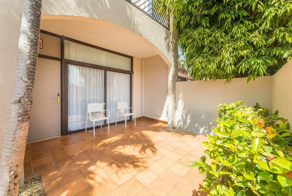 Tiled guest room patio with two chairs at Wyndham Palmas Beach and Golf Boutique Resort.