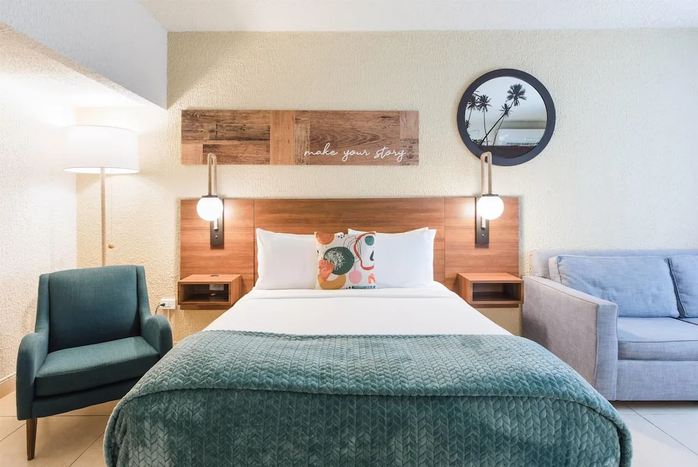King guest room with sofa, armchair, and wall art at Wyndham Palmas Beach and Golf Boutique Resort.