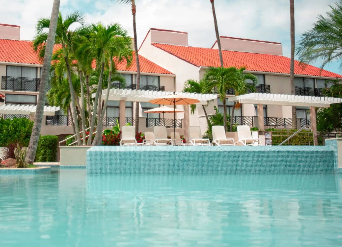 Pool deck with loungers and guest room buildings at Wyndham Palmas Beach and Golf Boutique Resort.