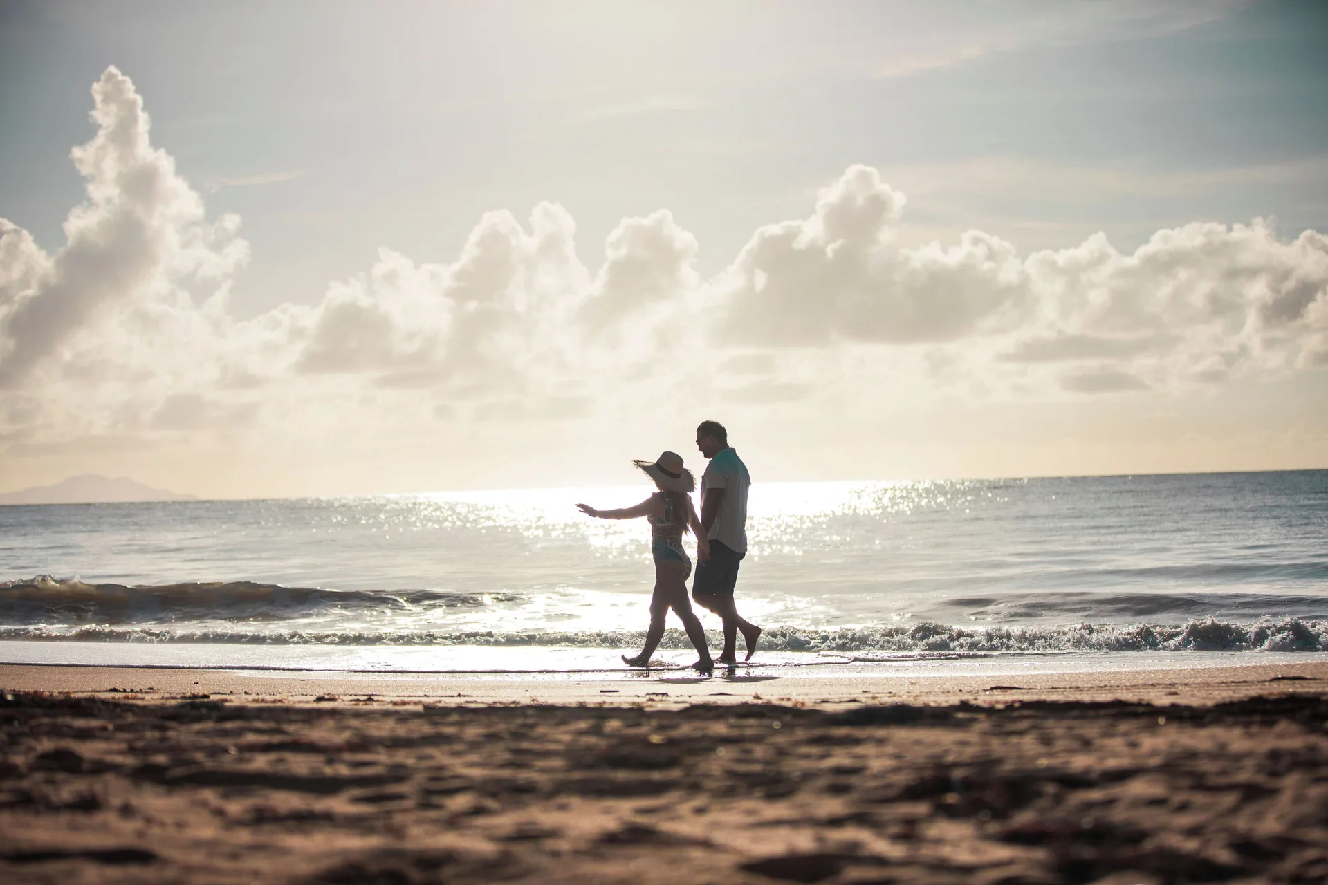 Two guests walk by the water at sunset at Wyndham Palmas Beach and Golf Boutique Resort.