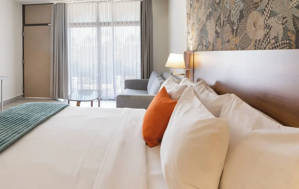 Garden view non-smoking room bed and sofa at Wyndham Palmas Beach and Golf Boutique Resort.