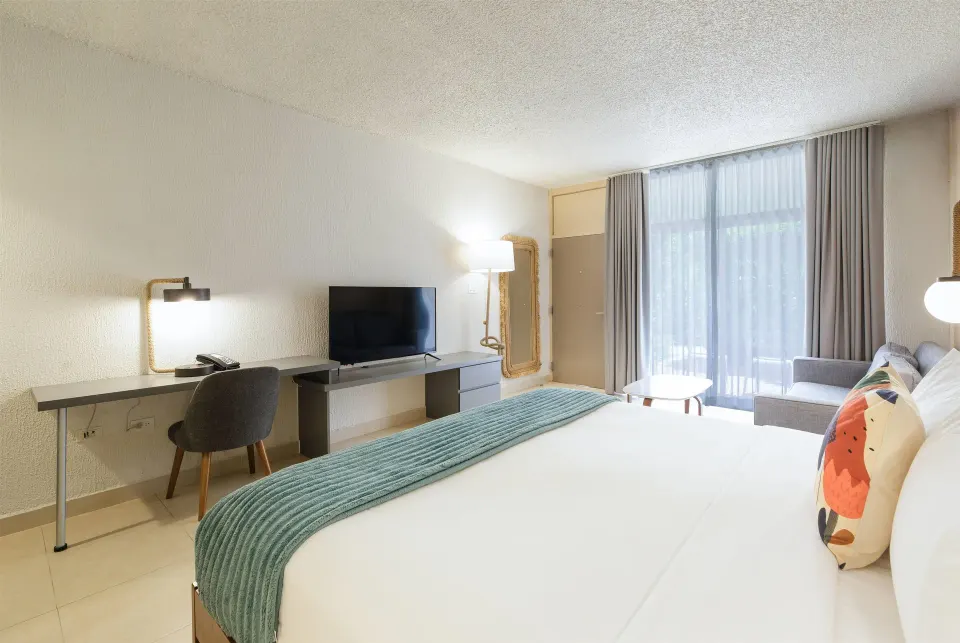 Poolside non-smoking room with king bed, desk, TV and sofa at Wyndham Palmas Beach and Golf Boutique Resort.