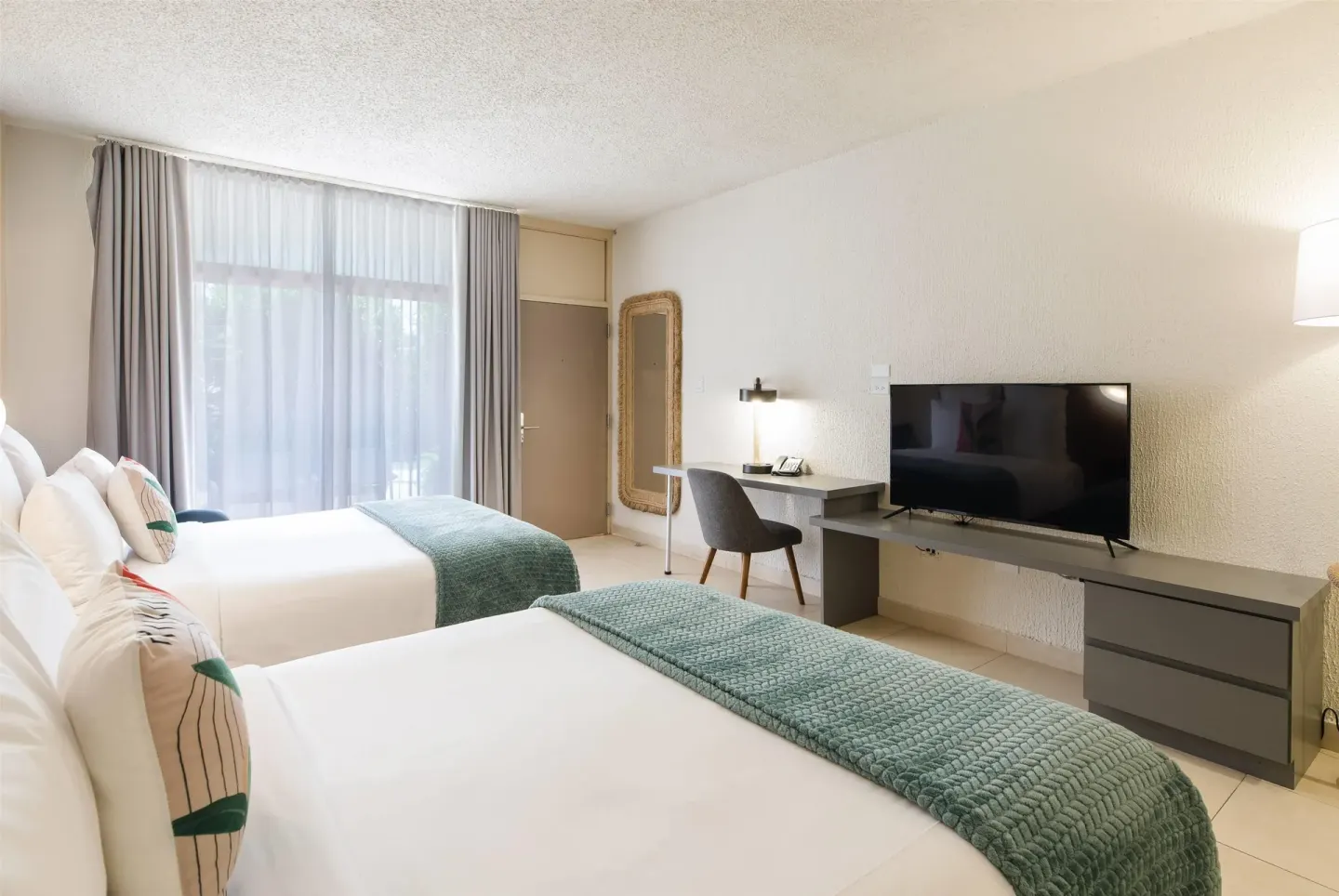 Two-bed poolside room with desk and TV at Wyndham Palmas Beach and Golf Boutique Resort.