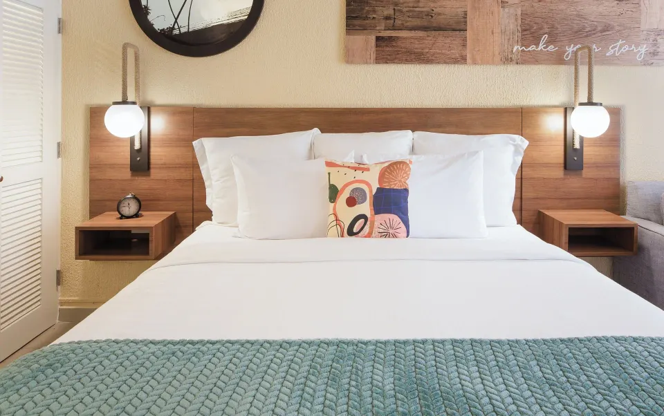Suite king bed with white linens and wood headboard at Wyndham Palmas Beach and Golf Boutique Resort.