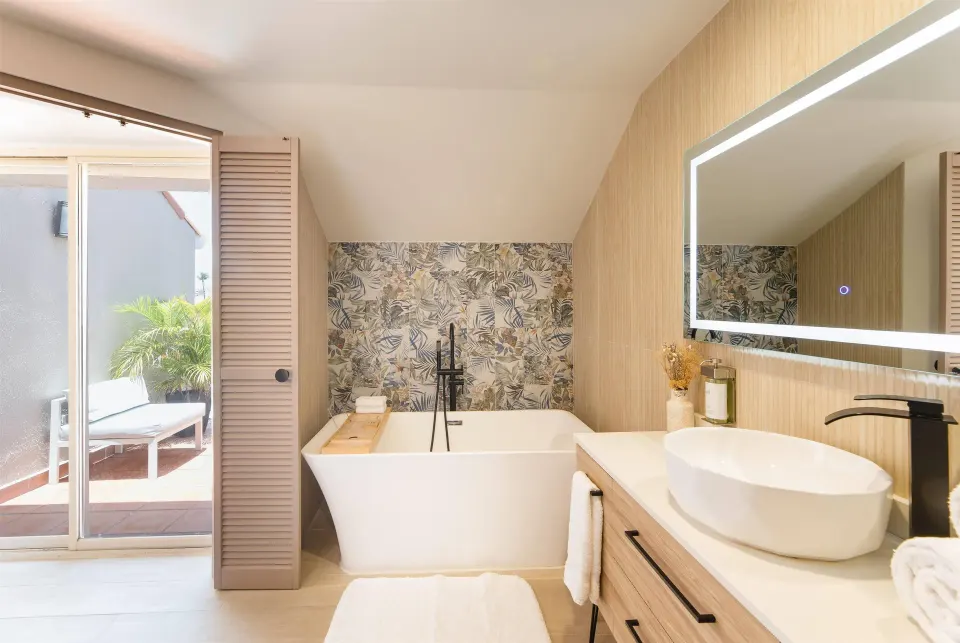 Suite bathroom with soaking tub and terrace door at Wyndham Palmas Beach and Golf Boutique Resort.