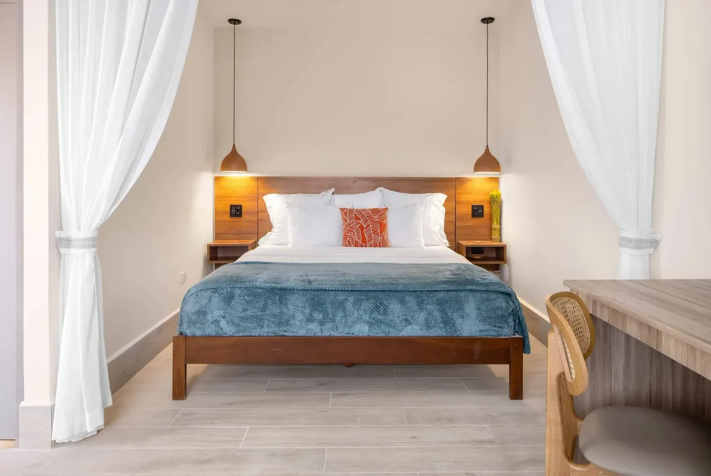 Suite king bed with pendant lights and desk at Wyndham Palmas Beach and Golf Boutique Resort.