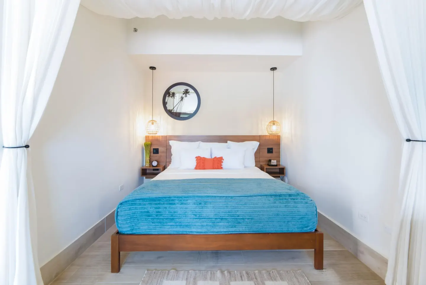 Suite king bed framed by white curtains at Wyndham Palmas Beach and Golf Boutique Resort.