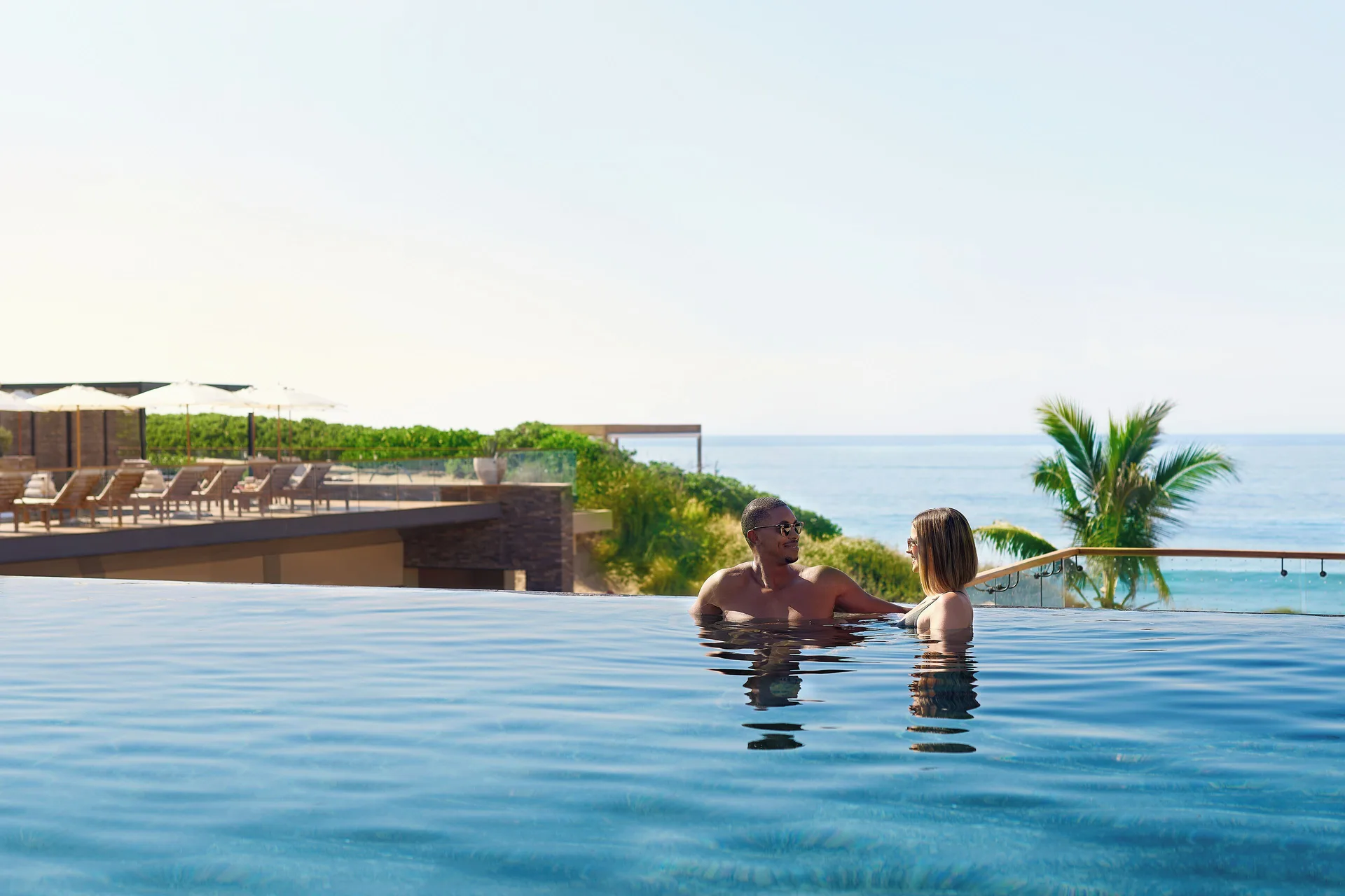Two guests in an infinity pool overlooking the sea at Zadún, a Ritz-Carlton Reserve, Los Cabos.