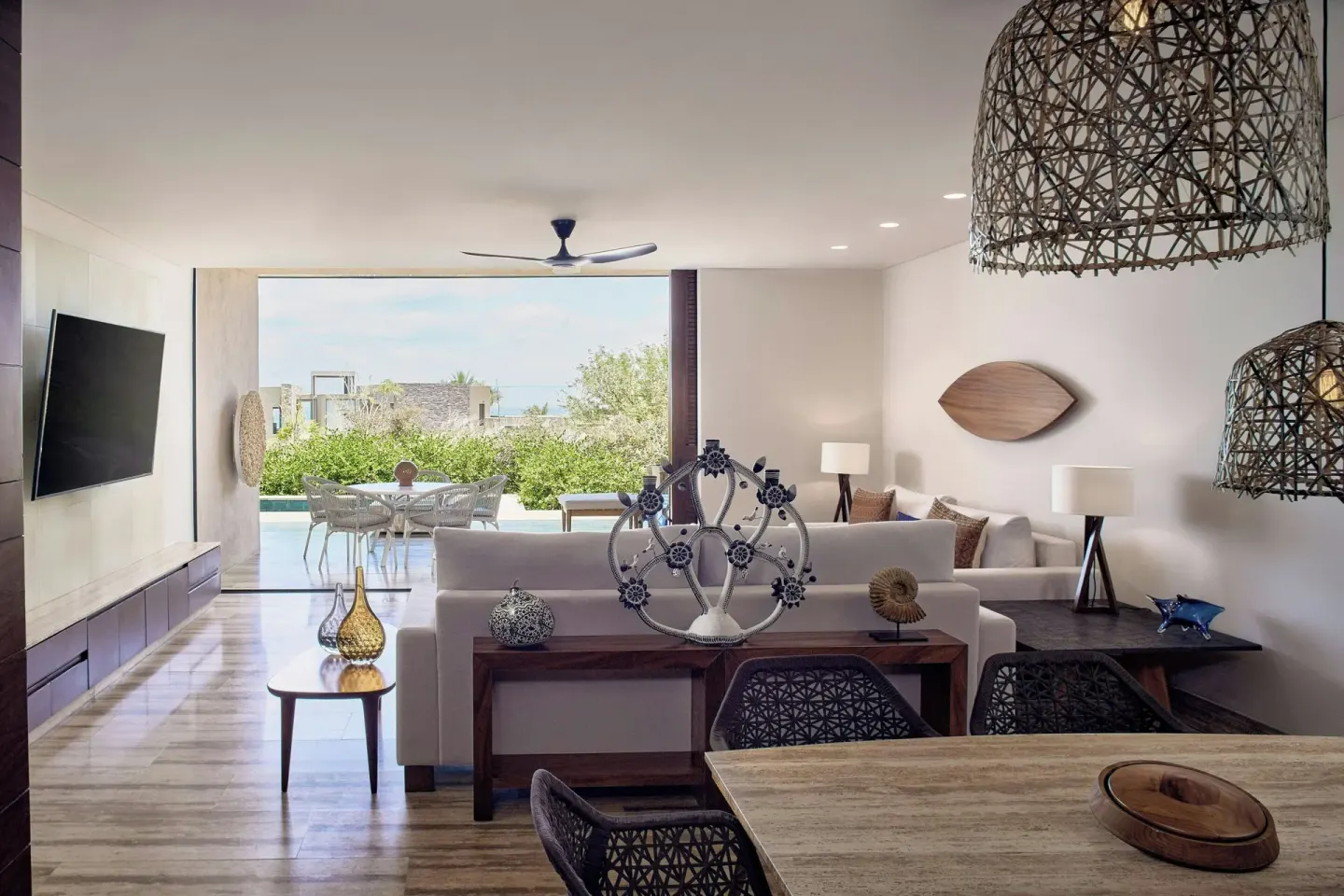 Living room with woven pendant lights and terrace beyond at Zadún, a Ritz-Carlton Reserve, Los Cabos.