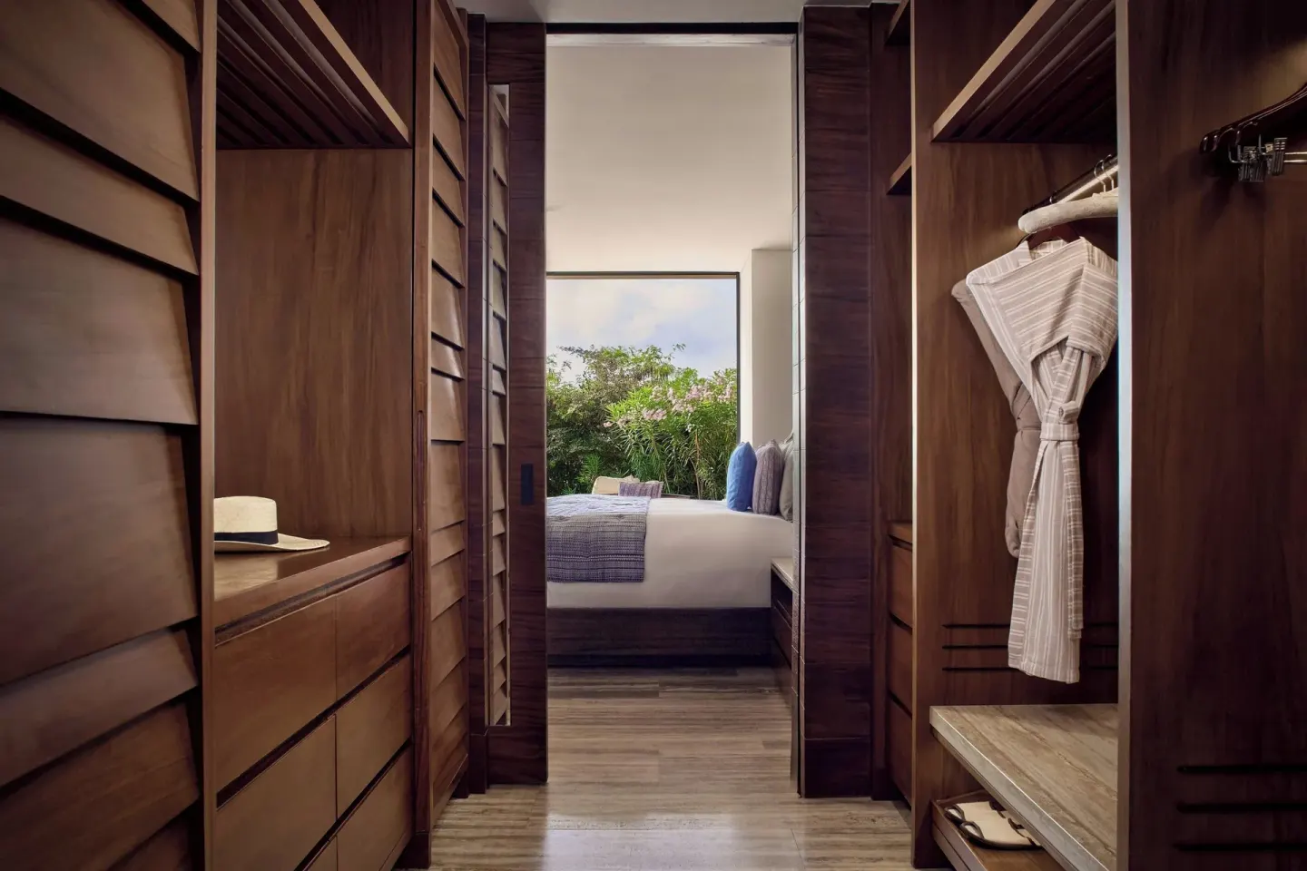 Wood-paneled dressing area with robe at Zadún, a Ritz-Carlton Reserve, Los Cabos.