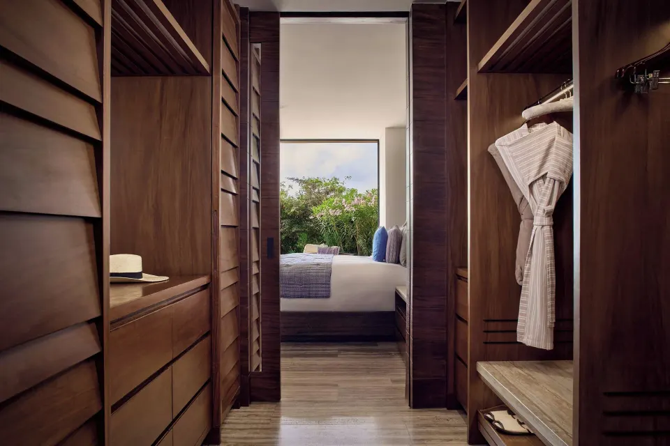Wood-paneled dressing area with robe at Zadún, a Ritz-Carlton Reserve, Los Cabos.