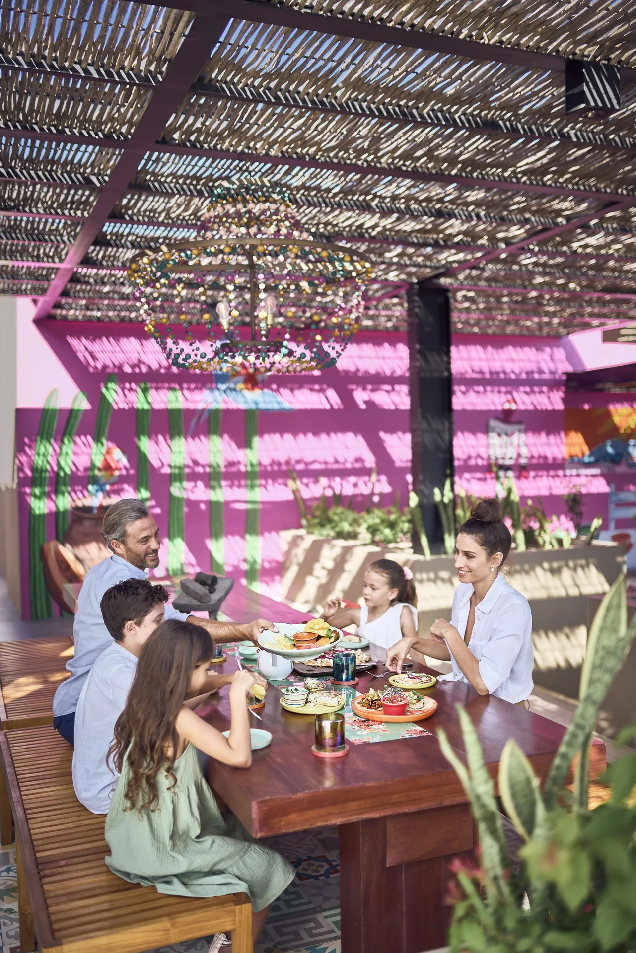 A family dines under a woven canopy at El Barrio at Zadún, a Ritz-Carlton Reserve, Los Cabos.