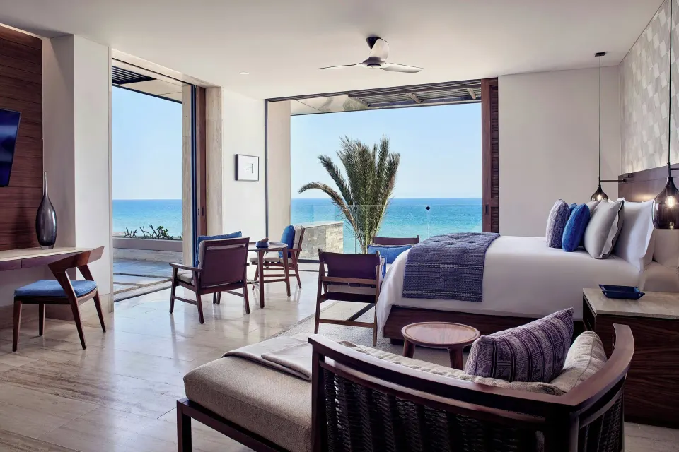 King guest room with open terrace, palm, and ocean view at Zadún, a Ritz-Carlton Reserve, Los Cabos.