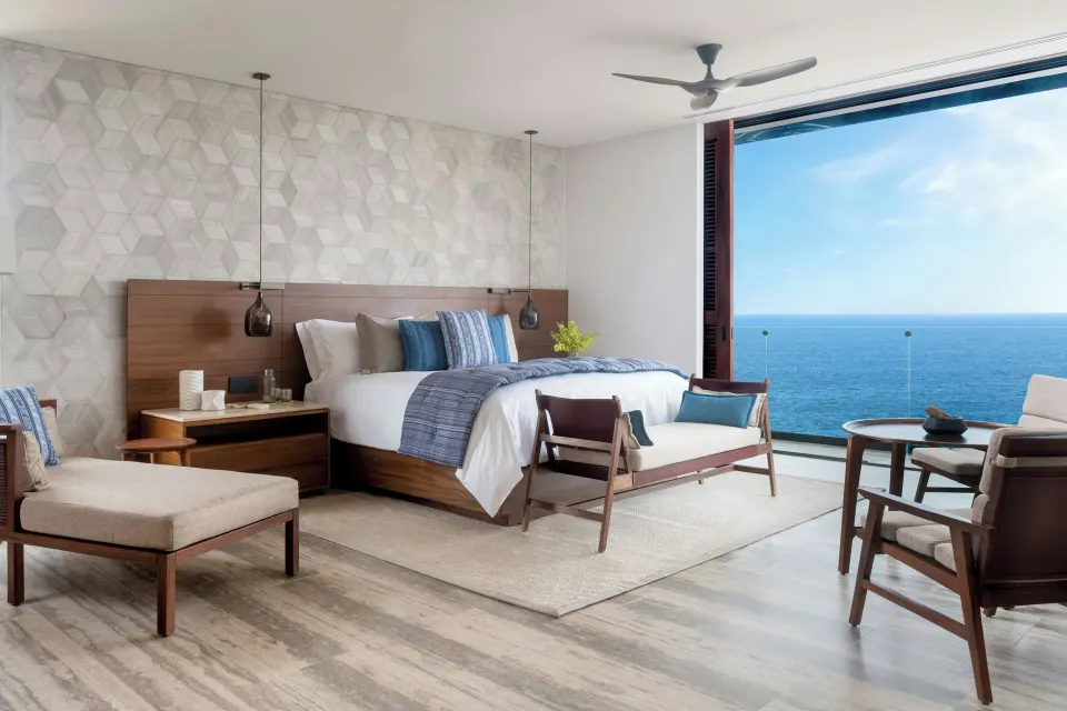 King guest room with seating area and ocean-facing glass wall at Zadún, a Ritz-Carlton Reserve, Los Cabos.