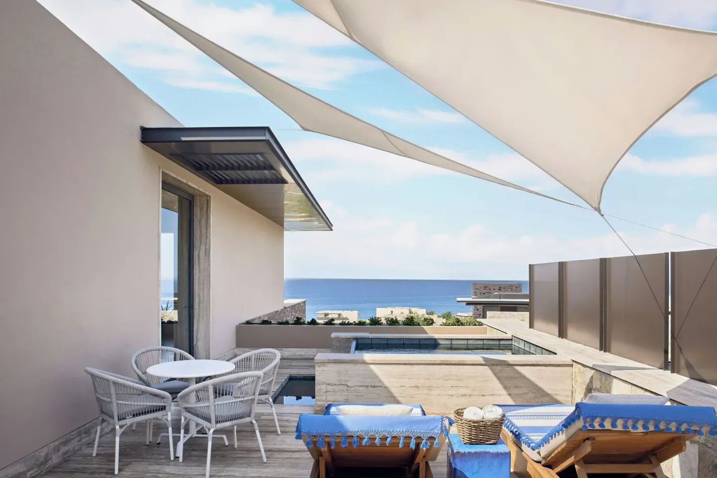 Shaded oceanfront terrace seating and loungers at Zadún, a Ritz-Carlton Reserve, Los Cabos.