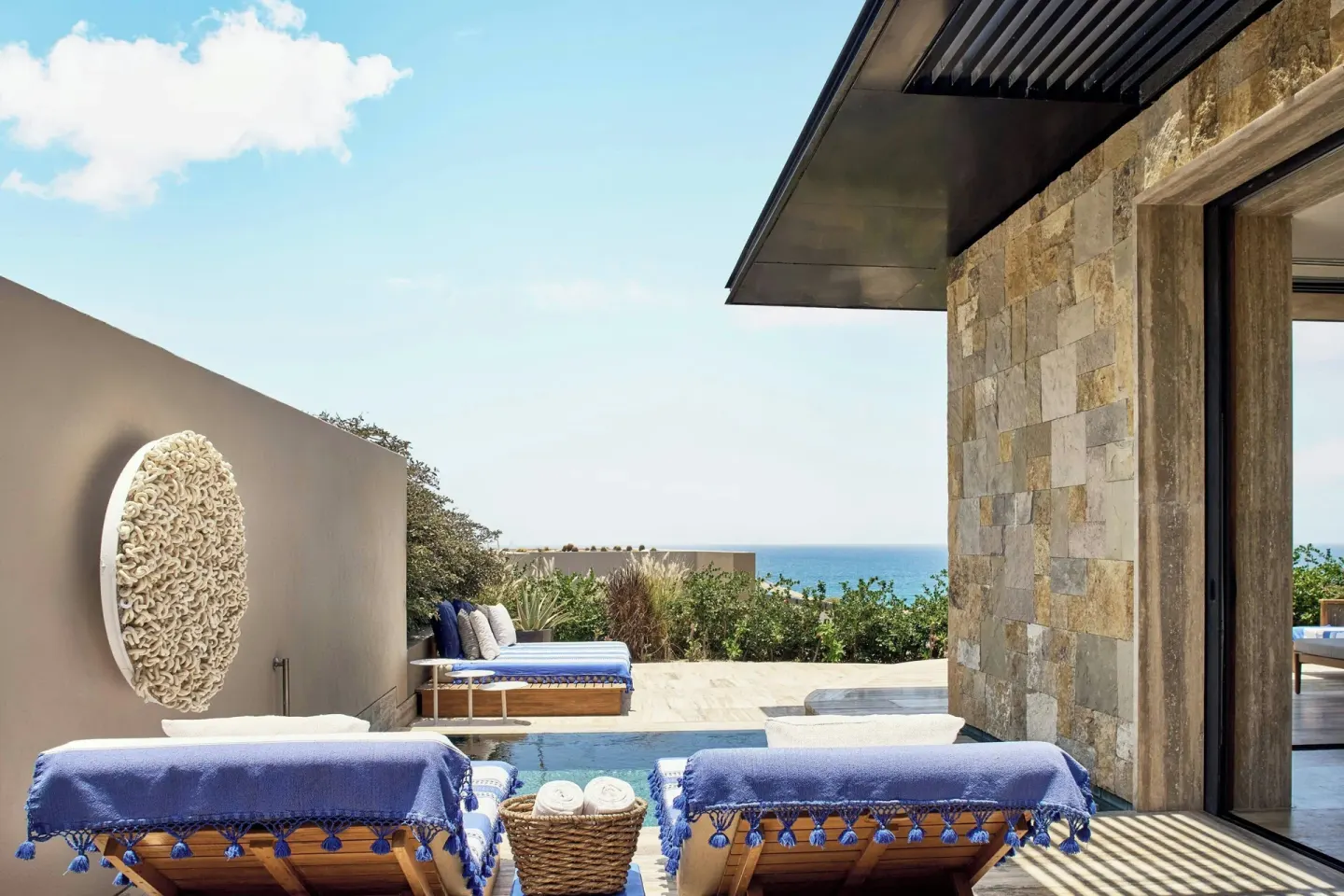 Terrace loungers, plunge pool, and stone room exterior at Zadún, a Ritz-Carlton Reserve, Los Cabos.
