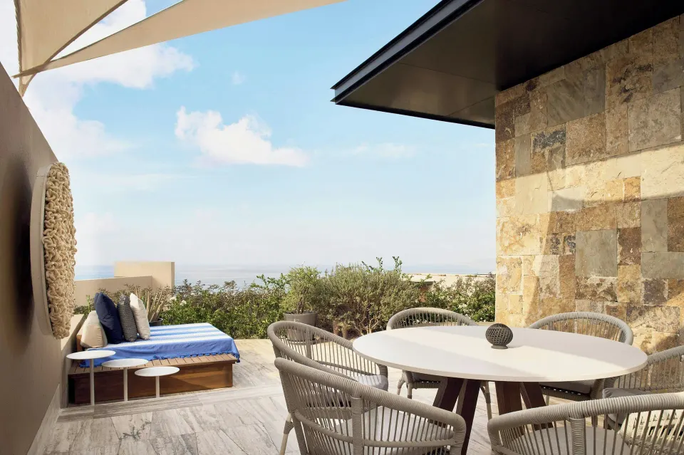 Oceanfront terrace with dining table and daybed at Zadún, a Ritz-Carlton Reserve, Los Cabos.