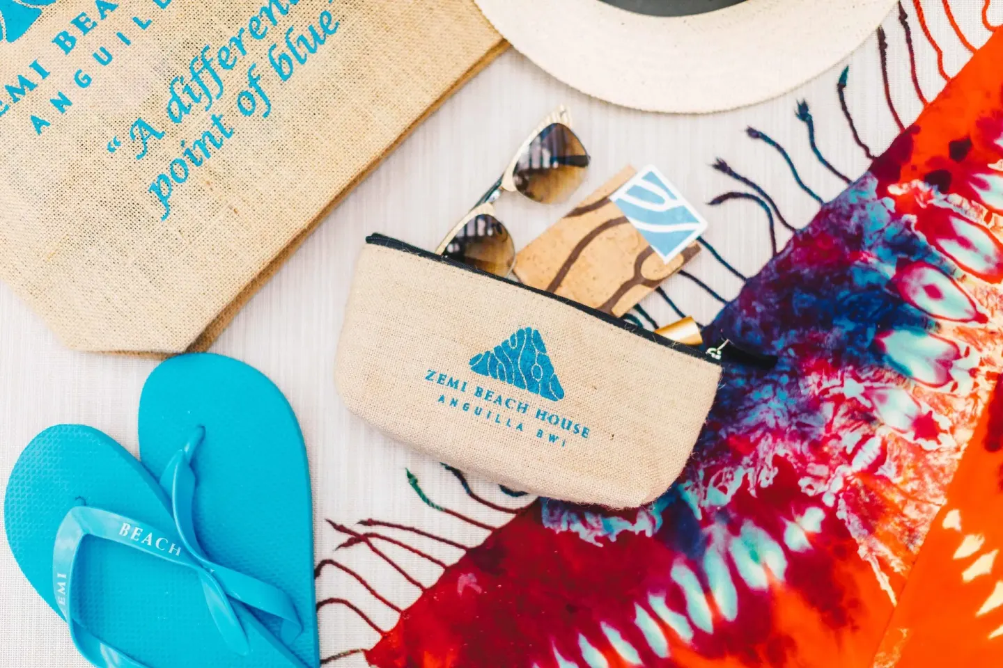 Beach accessories with branded pouch, flip-flops and colorful fabric at Zemi Beach House.