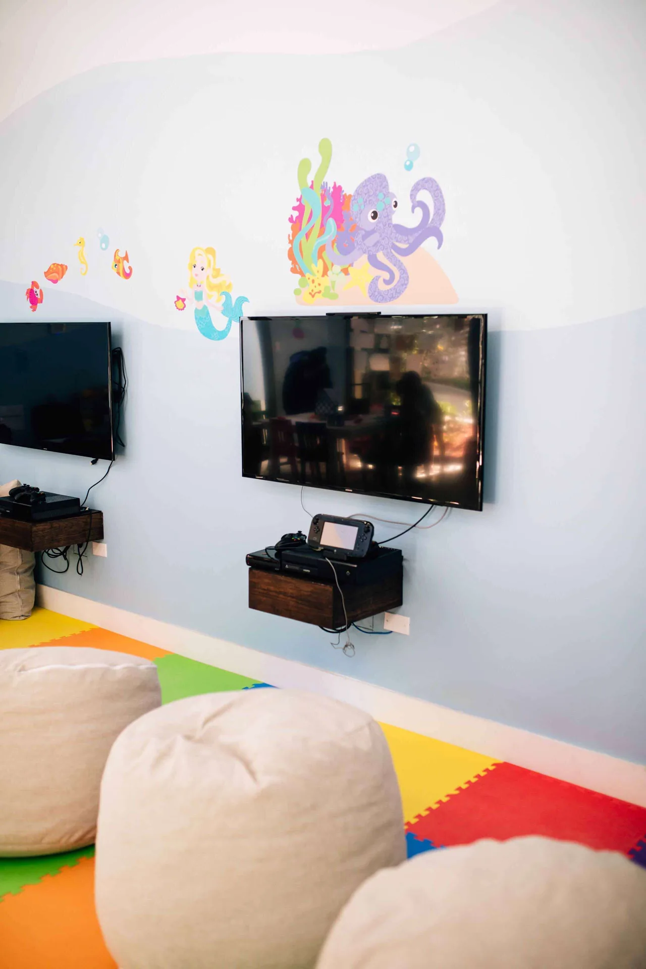 Wall-mounted screens and sea-life murals fill the Kids Club at Zemi Beach House.