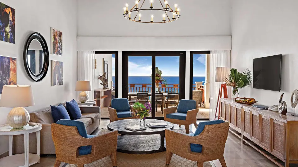 Ocean-view living room with blue chairs and balcony doors at Zemi Beach House.