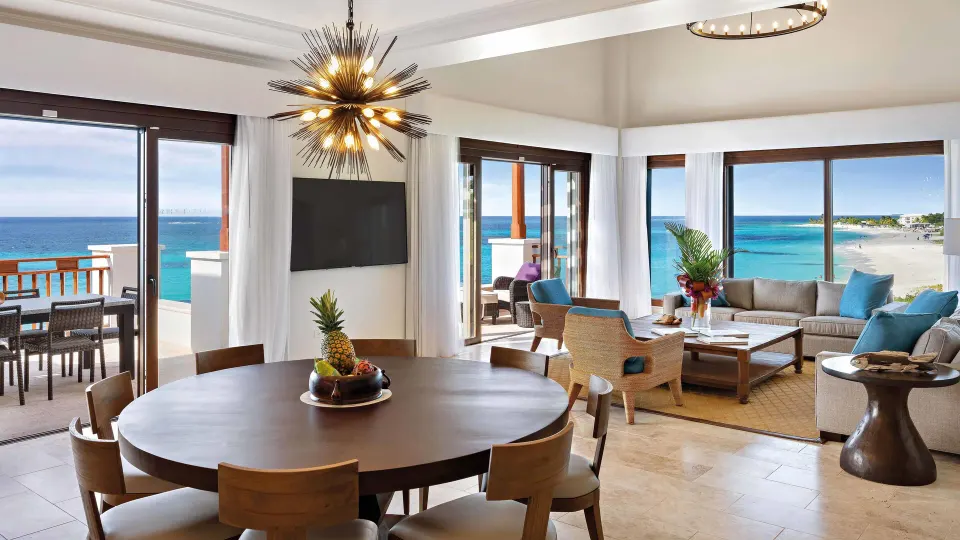 Oceanfront living and dining area with balcony views at Zemi Beach House.