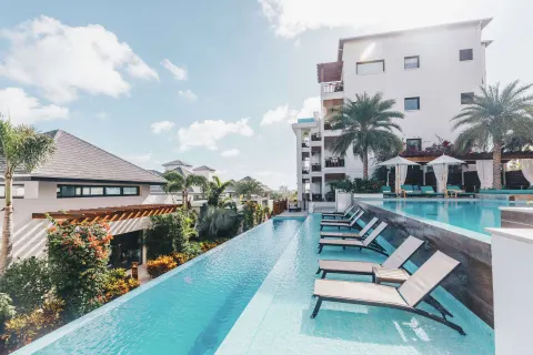 Resort pool with in-water loungers and guest buildings at Zemi Beach House.