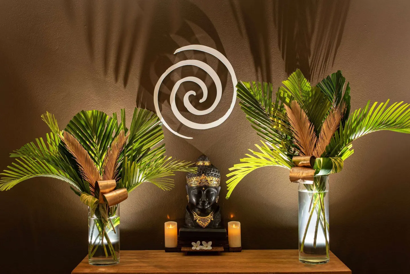 Spa decor with palm fronds, candles, and a statue at Zemi Beach House.