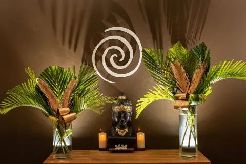 Spa decor with palm fronds, candles, and a statue at Zemi Beach House.