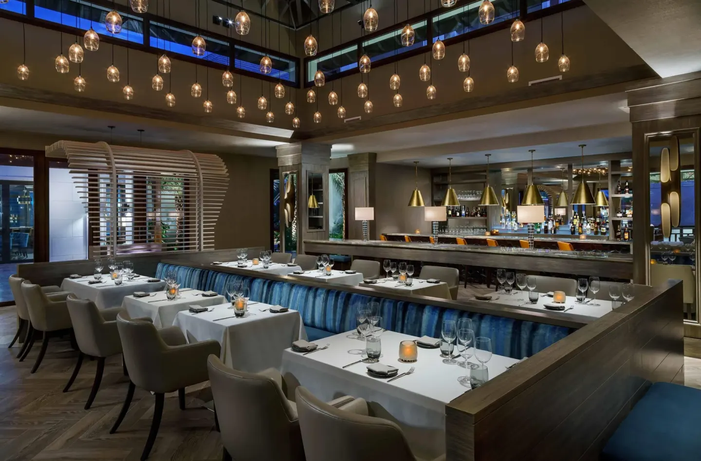 Elegant indoor dining room and bar with pendant lights at Zemi Beach House.