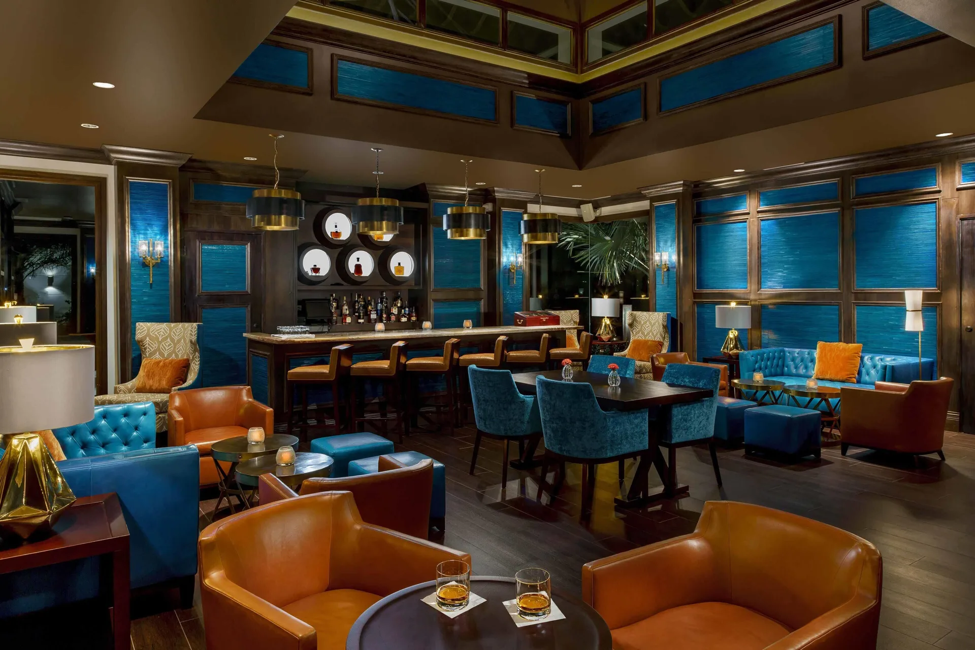 A blue and leather cocktail lounge with a bar inside Zemi Beach House.