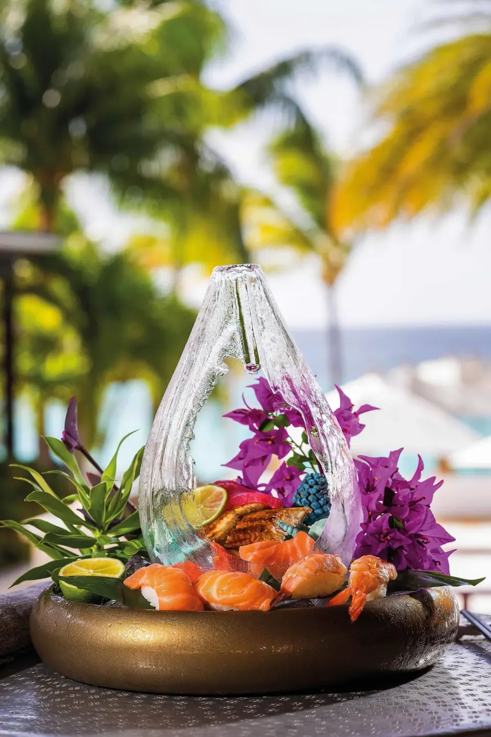 Sushi and seafood platter with floral garnish by the beach at Zemi Beach House.