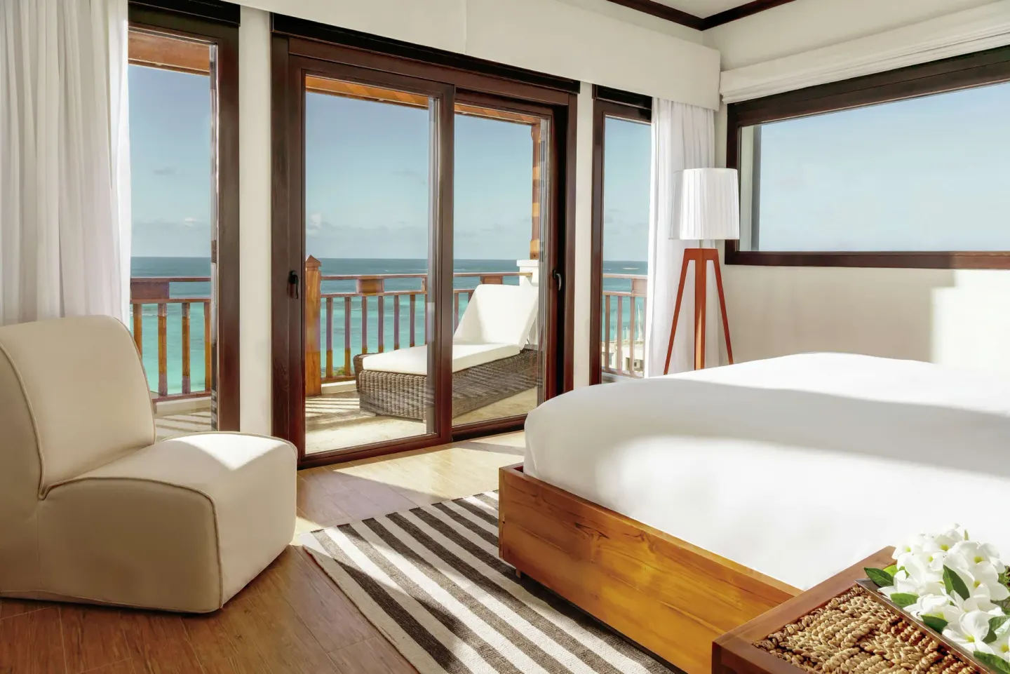 Ocean-view bedroom with balcony lounge chair in a penthouse at Zemi Beach House.