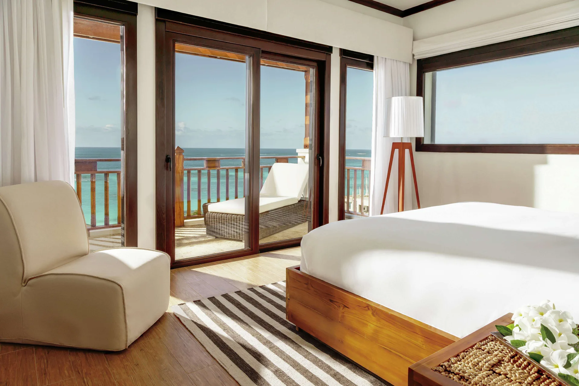 Ocean-view bedroom with balcony lounge chair in a penthouse at Zemi Beach House.