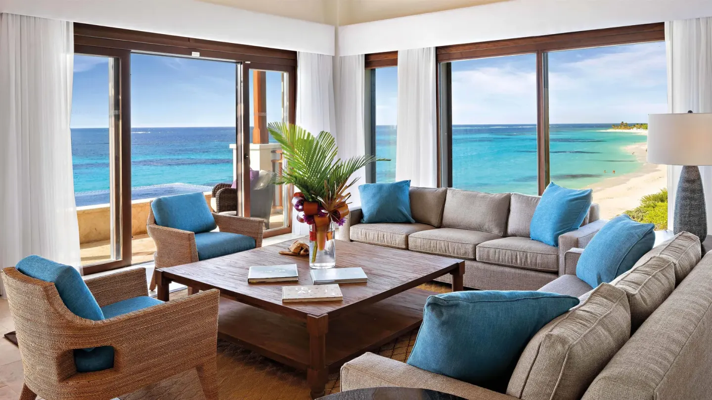 Oceanfront suite lounge with sofas and turquoise beach views at Zemi Beach House.